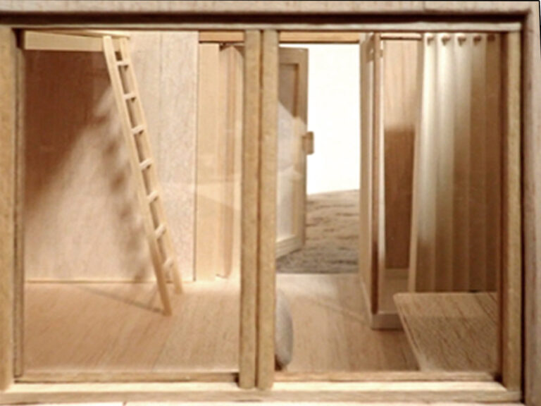 detail průhledu okna do modelu dřevěného domku